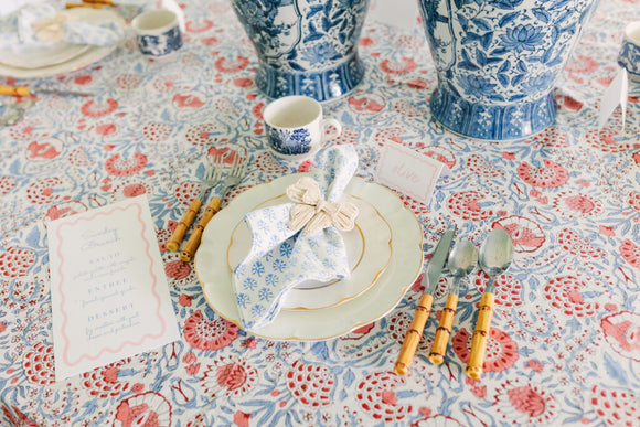 Table setting with blue vases and a red block printed tablecloth