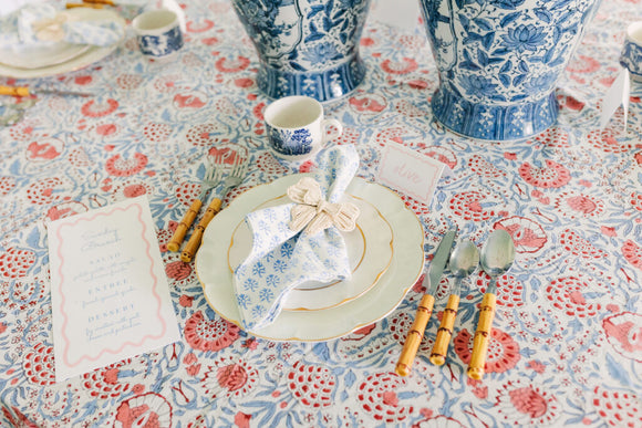 Table setting with blue vases and a red block printed tablecloth