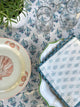 Blue and white block printed cocktail napkins on table beside plate