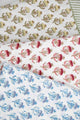Three block print tablecloths stacked on each other in green, red, and blue