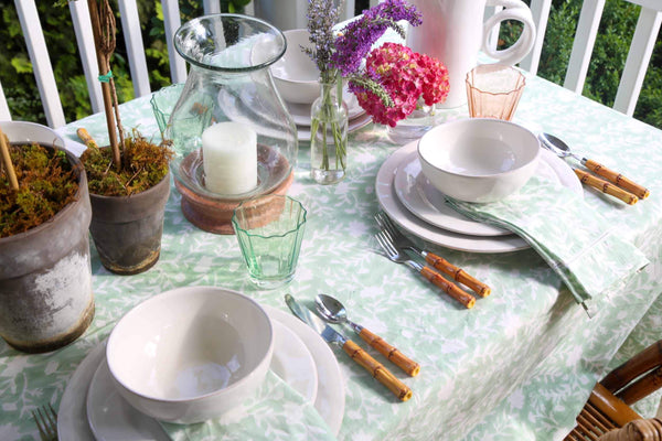 Camellia Tablecloth | Our Camellia print is a crowd-pleasing, grounded base upon which you can build any table scheme. With a calming ocean blue background and contrasting pale blue outlines, this tangle of vines adds sophistication and season-less warmth