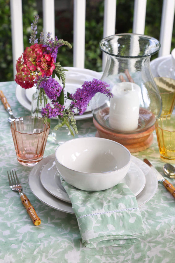 Camellia Tablecloth | Our Camellia print is a crowd-pleasing, grounded base upon which you can build any table scheme. With a calming ocean blue background and contrasting pale blue outlines, this tangle of vines adds sophistication and season-less warmth
