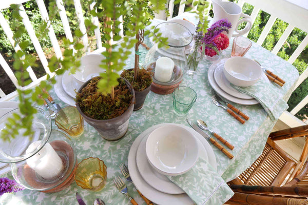Camellia Tablecloth | Our Camellia print is a crowd-pleasing, grounded base upon which you can build any table scheme. With a calming ocean blue background and contrasting pale blue outlines, this tangle of vines adds sophistication and season-less warmth