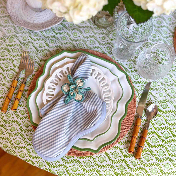 Flower napkin ring on blue napkin and green tablecloth