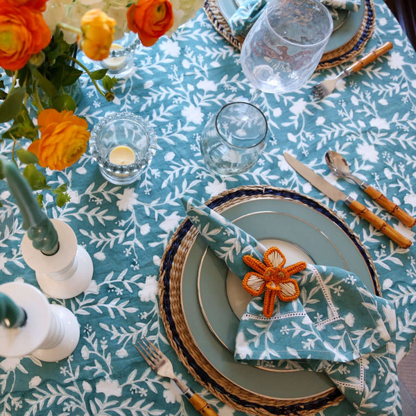 Camellia Tablecloth | Our Camellia print is a crowd-pleasing, grounded base upon which you can build any table scheme. With a calming ocean blue background and contrasting pale blue outlines, this tangle of vines adds sophistication and season-less warmth