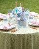 Table set with plates, blue wine glasses, and green round tablecloth