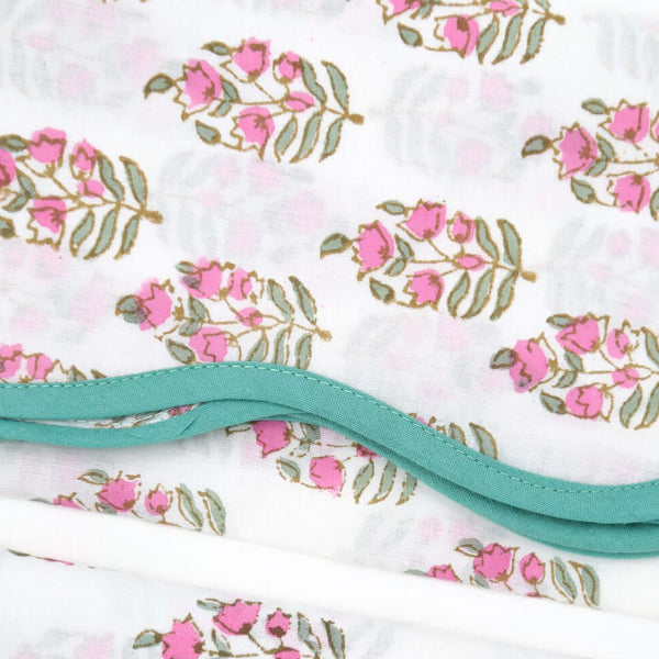 pink and white block printed napkin with green piping
