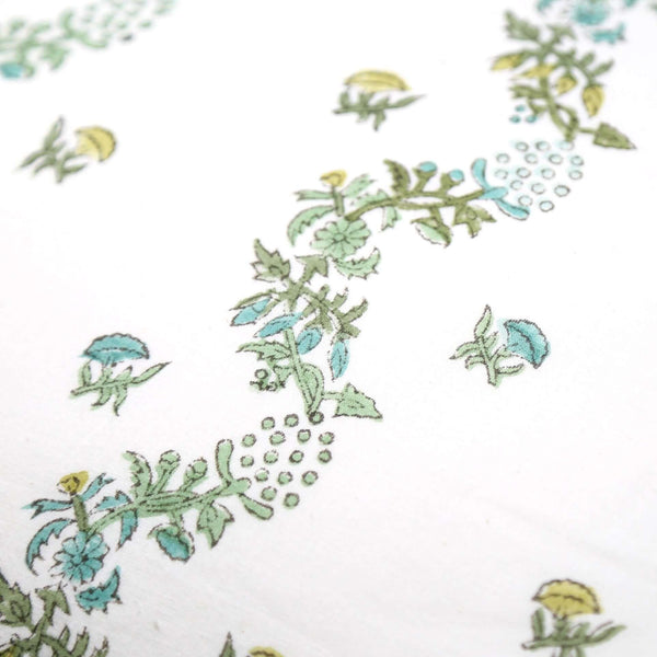 Close up of white and green block printed pillow cover