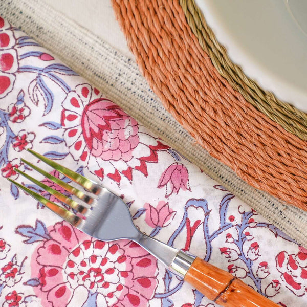 Pink and blue block printed cotton napkin beside placemat and plate