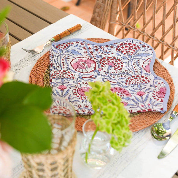 Pink and blue block printed cotton napkins on placemat with green flowers