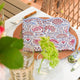 Pink and blue block printed cotton napkins on placemat with green flowers