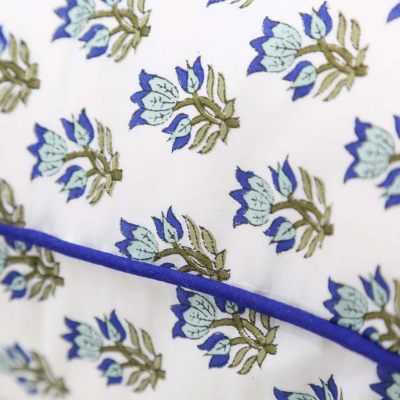 Close up of blue and green floral pillow cover with blue pipping