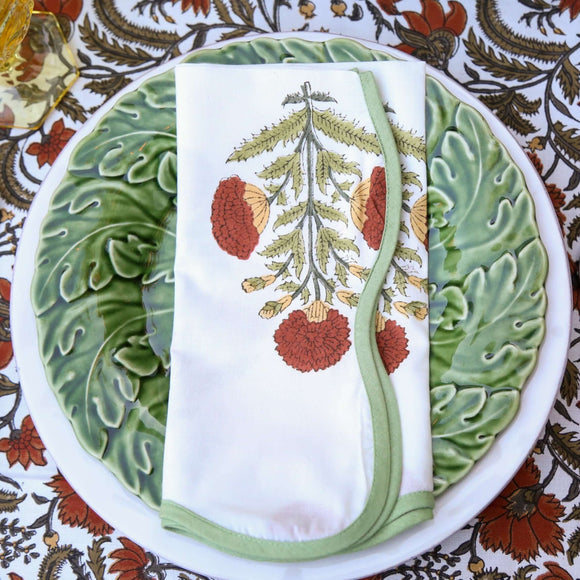 Red and white floral block printed napkin on green plates