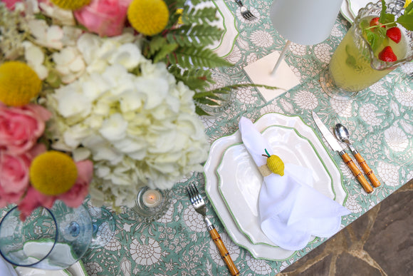 Table setting with flowers and green block printed tablecloth