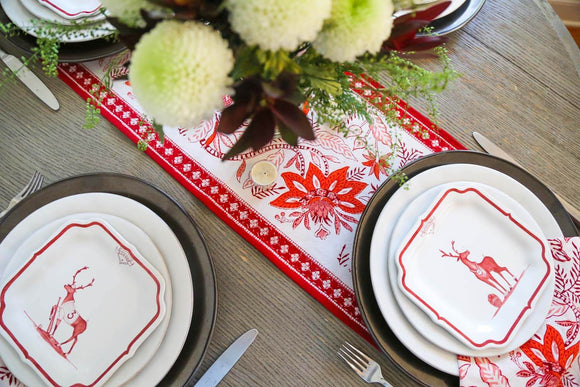 Red and white block printed table runner with Christmas plates