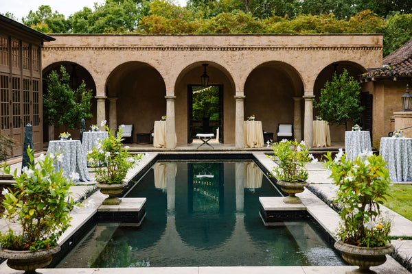 Outdoor pool with cocktail tables and green plants