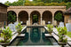 Outdoor pool with cocktail tables and green plants