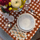 Orange block printed gingham rectangle tablecloth with white plate