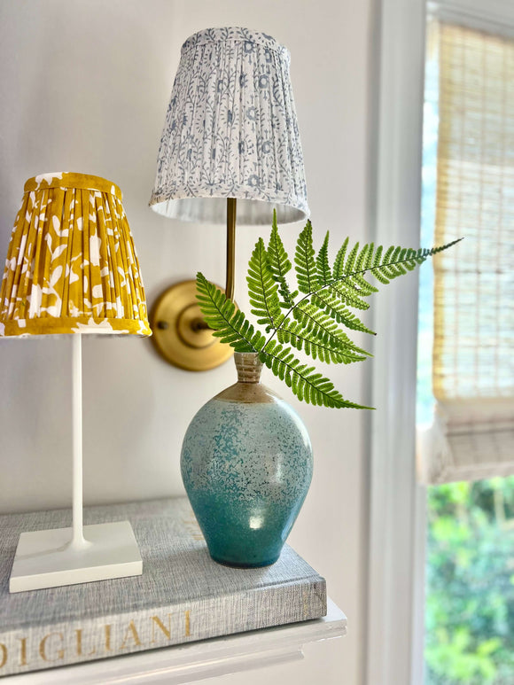 Yellow block printed lampshade on mantle with green plant