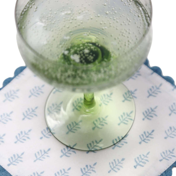 Green martini glass on block print cocktail napkin with small trees