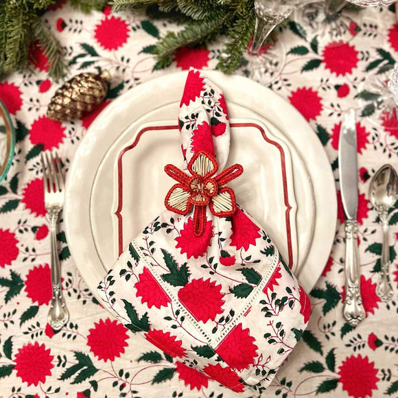 Table setting with red and white floral napkin on plate