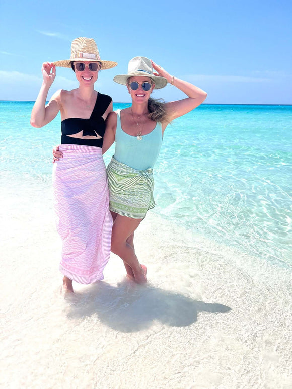 Two girls on tropical beach wearing block printed pareo cover ups