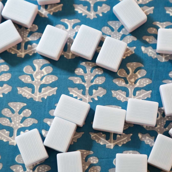 Mahjong tiles on blue block printed tablecloth