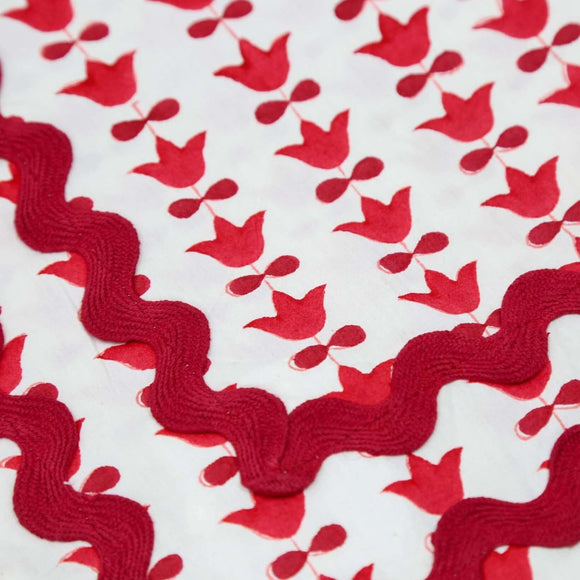 Close up of red and white block printed tablecloth with red ricrac trim