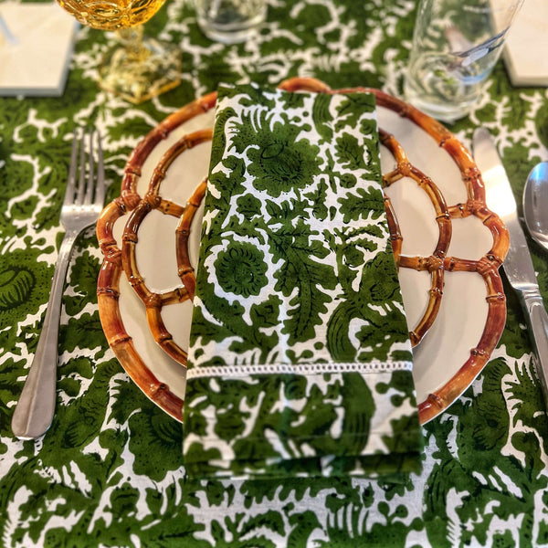 Green block printed napkin on plate with green tablecloth