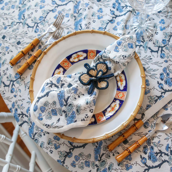 Blue floral block printed napkin on plate with woven napkin ring
