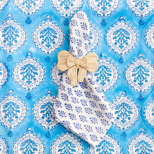 Woven bow napkin ring on blue block printed fabric