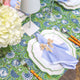 Green block printed tablecloth with flowers and blue napkin