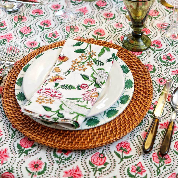 Table setting with plate, placemat, and block print napkin on pink and green tablecloth
