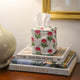 Pink and green floral tissue box cover on books
