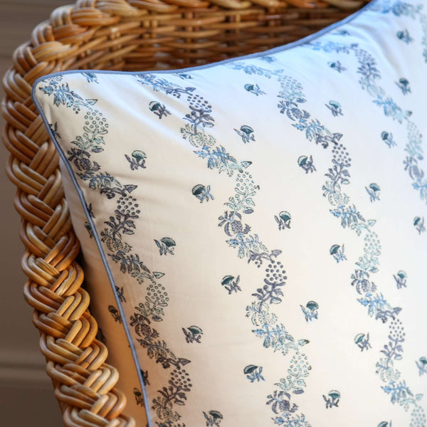 White and blue block printed pillow cover on wicker chair