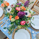 Dining table set with plates, flowers and blue block printed tablecloth